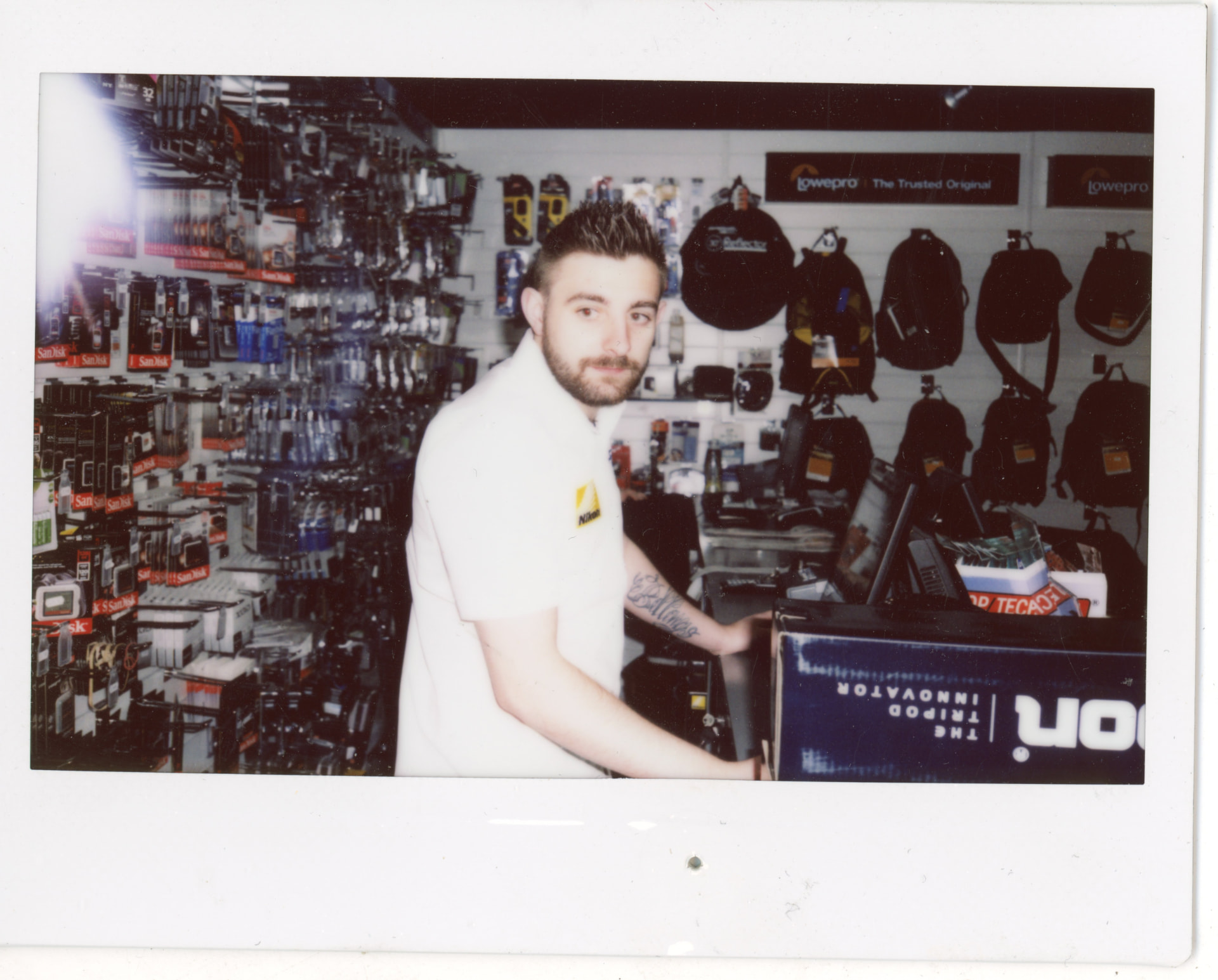 Instax photo of a Camera Centre UK staff member behind the counter